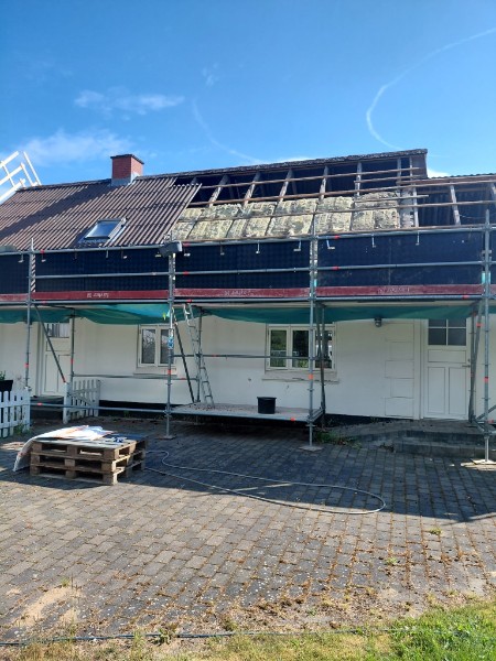 Stillads opsat omkring landhus med delvist nedtaget asbesttag
